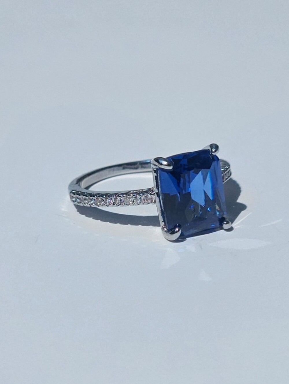 Silver Ring with Deep Blue Emerald-Cut Gemstone and Pavé Band